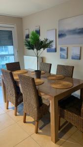 einem Esstisch mit Stühlen und einer Topfpflanze in der Unterkunft Appartement “zon en vakantie aan zee” in Koksijde