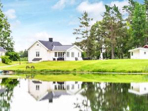 a house with a pond in front of it at 6 person holiday home in ÅSBRO-By Traum in Åsbro