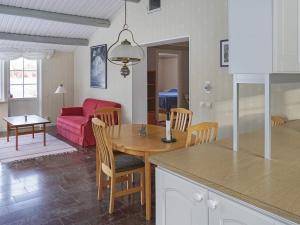 een keuken en een woonkamer met een tafel en een bank bij Holiday home ÅSBRO III in Åsbro
