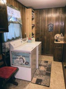 eine Waschmaschine und einen Trockner in einem Zimmer mit Holzwänden in der Unterkunft Maggie’s lil Cottage in Sampson