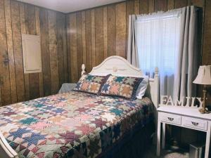ein Schlafzimmer mit einem Bett mit einer Decke darauf in der Unterkunft Maggie’s lil Cottage in Sampson