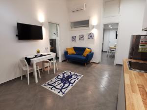 a living room with a blue chair and a table at Octopus Vietri House in Vietri sul Mare