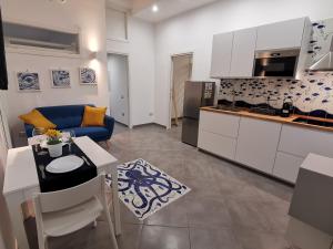 a kitchen and a living room with a blue couch at Octopus Vietri House in Vietri sul Mare
