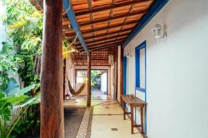 a porch with a hammock in a house at Tropicália Hostel e Pousada in Itacaré
