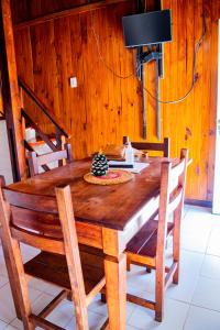 una mesa de comedor de madera con sillas y una lámpara en Doña Margarita en Chascomús