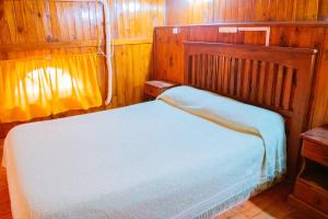 1 dormitorio con 1 cama en una habitación de madera en Doña Margarita en Chascomús