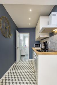 a kitchen with blue walls and a checkered floor at @Romantic Suite & Spa @Jacuzzi @ Parking gratuit @ in Mulhouse