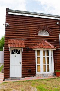 Casa de madera pequeña con puerta blanca en Doña Margarita en Chascomús