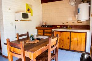 cocina con mesa de madera con sillas y fregadero en Doña Margarita en Chascomús