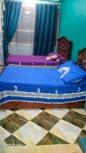 a bedroom with a bed with blue sheets and a window at شقق وشليهات رشيد علي ضفاف بحيره قارون in Shakshuk