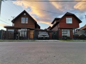 una casa con una valla de madera y una puerta en Apartasuite Altos del Bosque, en Punta Arenas