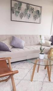 sala de estar con sofá blanco y mesa de cristal en Departamento Nuevo Pucón, en Pucón