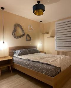 1 dormitorio con 1 cama y algunas decoraciones en la pared en OLGA Chambre d'hote en Verdun