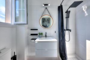 ein weißes Bad mit einem Waschbecken und einer Dusche in der Unterkunft Cosycocoon La Bastide in Draguignan