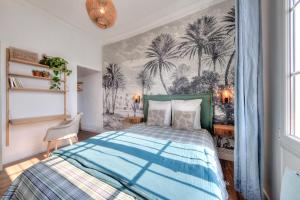 ein Schlafzimmer mit einem Bett und Palmen-Tapeten in der Unterkunft Cosycocoon La Bastide in Draguignan