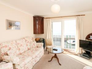 a living room with a couch and a tv at 6 Lyme Mews in Seaton