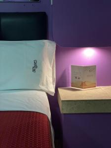 a bedroom with a bed and a book on a shelf at Motel Las Dunas in Mexicali