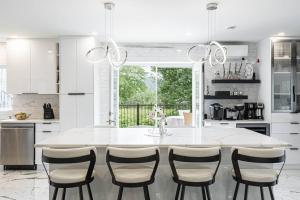 Shefford的住宿－B&B Suite INN Abondance & SPA，白色的厨房配有大白色的桌子和椅子