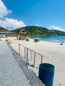 une plage avec un seau bleu sur le sable dans l'établissement Apartamento da Prainha, à Arraial do Cabo 31 autres photos