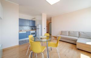 a kitchen and living room with a glass table and yellow chairs at Awesome Apartment In Genova With Wifi in Genoa