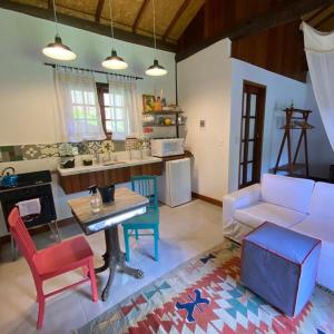 a living room with a white couch and a table at Bangalo a beira do rio em plena natureza in Petrópolis