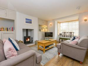 a living room with two couches and a fireplace at Camelot Cottage in Port Isaac