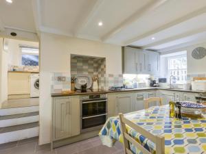 a kitchen with a table and a dining room at Camelot Cottage in Port Isaac