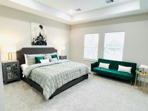 um quarto com uma cama e um sofá verde em Upcoming Houston Down 3 Bedroom brand new listing em Houston