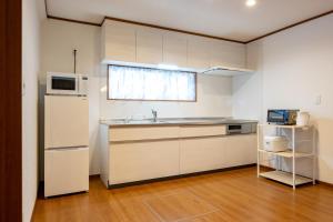 cocina con fregadero y microondas en neige furano Vacation rented house en Furano