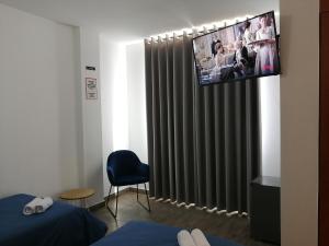a room with a tv hanging above a radiator at Casa Yuraq Hotel Boutique in Chincha Alta