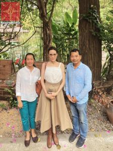 un groupe de trois personnes posant pour une photo dans l'établissement Maisons Wat Kor, à Battambang