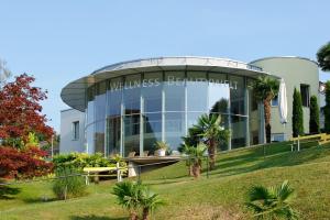ein Gebäude in einem Park mit Palmen in der Unterkunft See & Wellnesshotel Gerbi in Weggis
