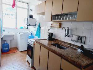 a kitchen with a sink and a counter top at Aconchego no Rio in Rio de Janeiro