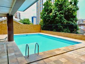 una gran piscina con una silla junto a ella en Aconchego e tranquilidade no Rio de Janeiro - Méier, en Río de Janeiro