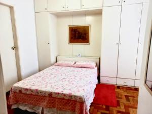 een kleine slaapkamer met een bed en witte kasten bij Aconchego no Rio in Rio de Janeiro