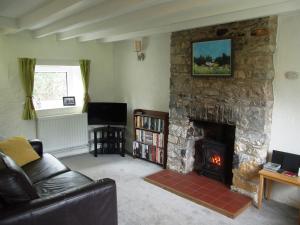a living room with a stone fireplace and a couch at Pwll Cottage in Carmarthen