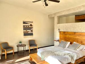 1 dormitorio con 1 cama, 2 sillas y mesa en Luna Del Valle, en Valle de Guadalupe