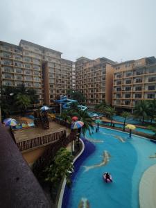 a large swimming pool with umbrellas in a resort at Buluh Inn @ Gold Coast Morib in Banting