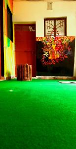 a room with a green floor and a red door at BlaBla Hostel in Rishīkesh