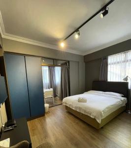 una camera con un grande letto e uno specchio di Greatwood Residence at Devonshire a Singapore