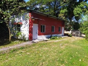 una casa de ladrillo rojo con una puerta blanca y un patio en The Leisure Home Stay en Shādipur