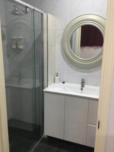 a bathroom with a shower, sink, and mirror at Ayrline Motel in Ayr