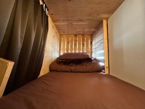 Bett in einem kleinen Zimmer mit Vorhang in der Unterkunft Only one group stays per day -Tenmaya-家族や仲間と貸し切りゲストハウス 天満屋 in Nakatsugawa