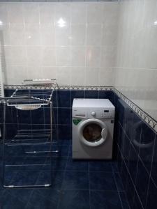 een badkamer met een toilet in een blauwe tegelkamer bij Guest House SAMAN in Garni