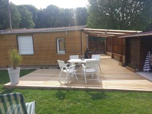 a wooden deck with a table and chairs on it at LES HERISSONS in Étricourt-Manancourt