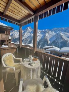 uma mesa e cadeiras numa varanda com vista para as montanhas em Apartment Di Lembah em Wiler