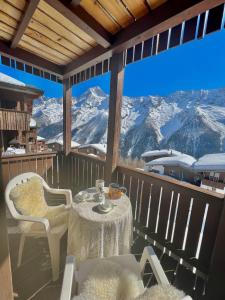 a table and chairs on a balcony with a view of mountains at Apartment Di Lembah in Wiler