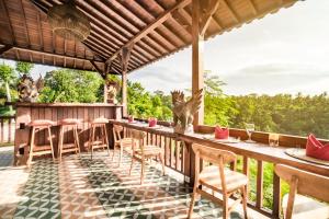 ein Restaurant mit einem Tisch und Stühlen auf einer Terrasse in der Unterkunft Magatama Villa by Mahaputra in Gianyar