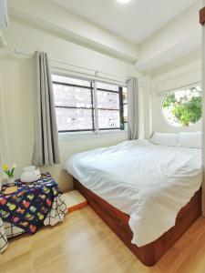 a bedroom with a large bed and a window at MiuMiu in da house. in Chiang Mai
