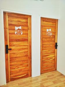 two wooden doors in a room next to each other at MiuMiu in da house. in Chiang Mai